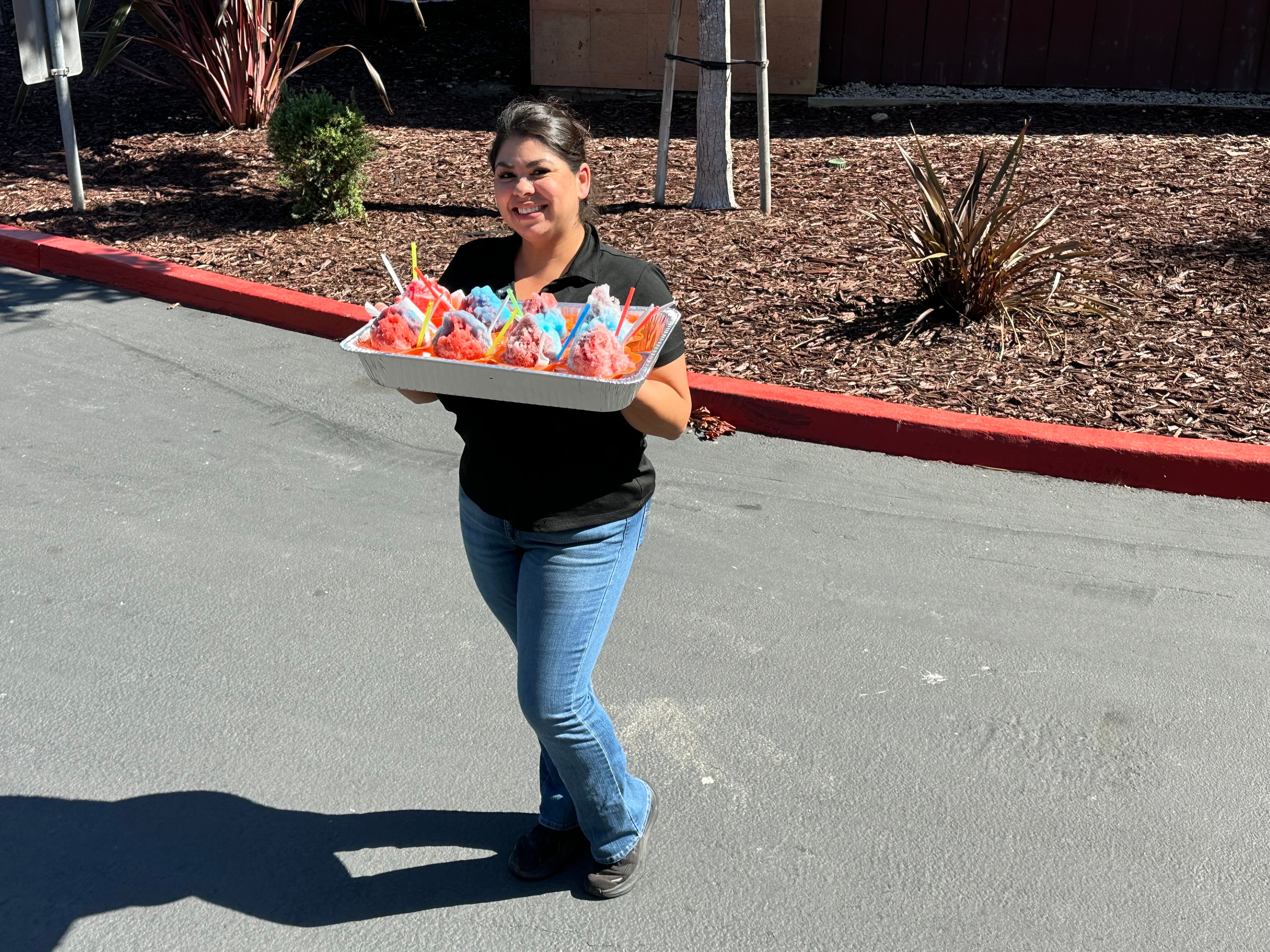 Woman carrying a tray of colorful shave ice at Shaka Shak