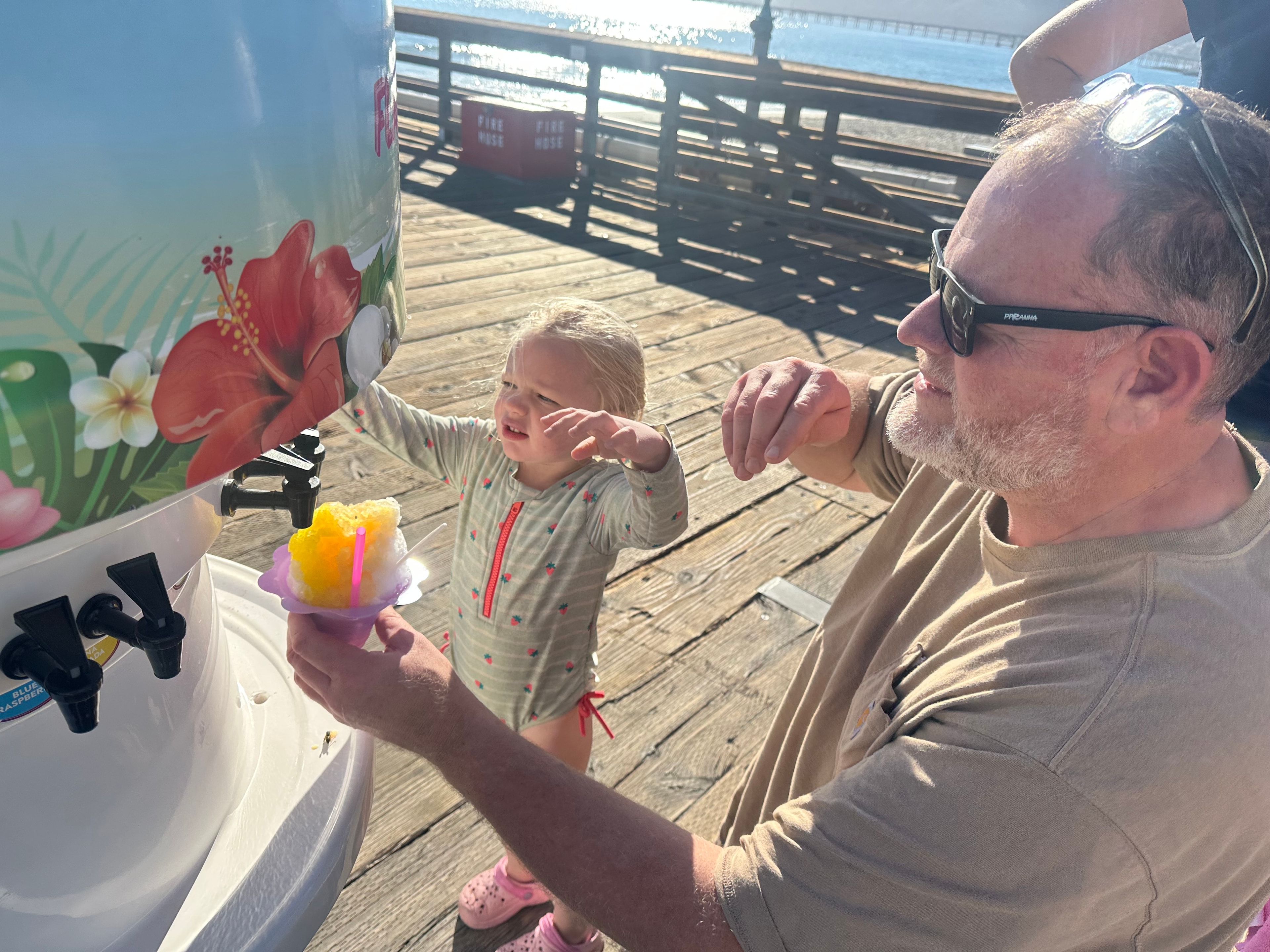 Dad and daughter at the Shaka Shak flavor station on the Avila Beach pier