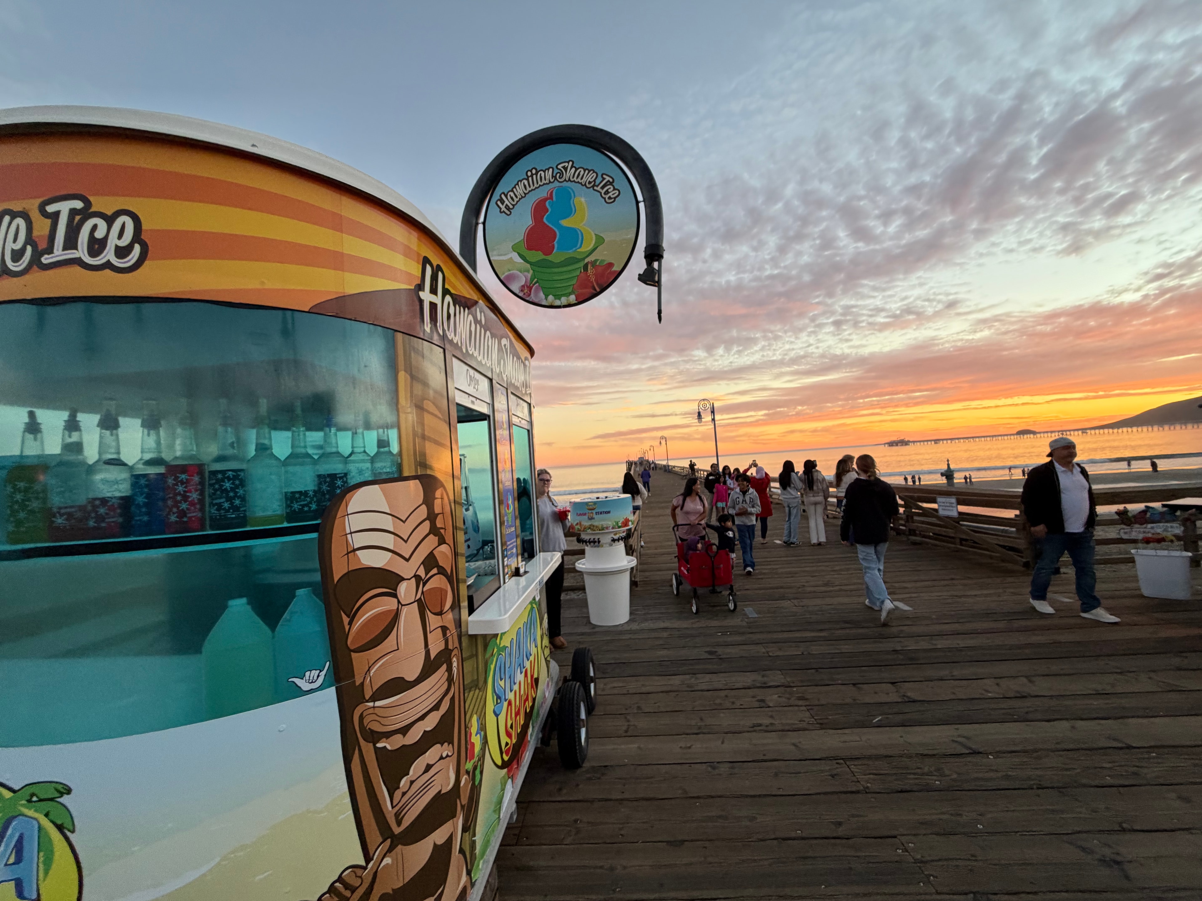 Shaka Shak kiosk on the Avila Beach pier at sunset with colorful sky