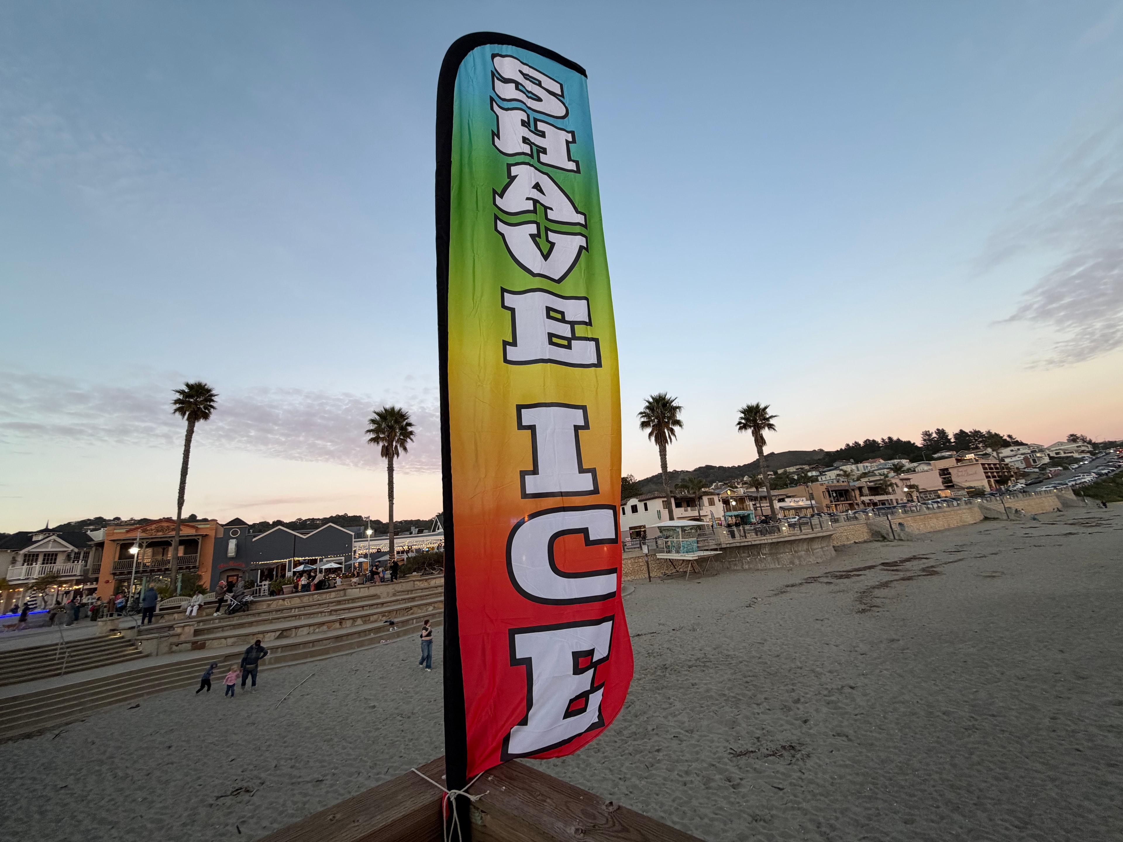 Colorful Shave Ice feather banner at sunset on the Avila Beach pier
