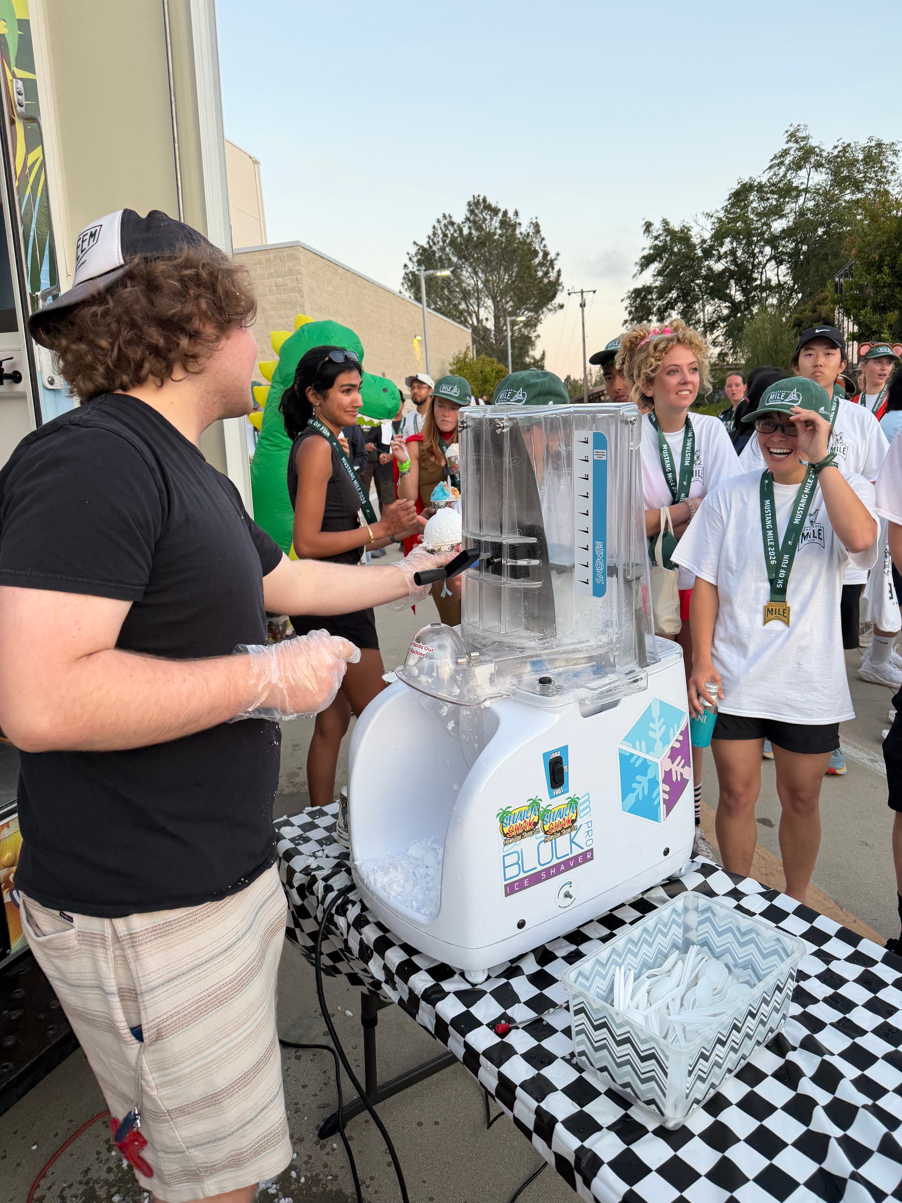 Shaka Shak staff making shave ice at the Mustang Mile 5K event with excited crowd