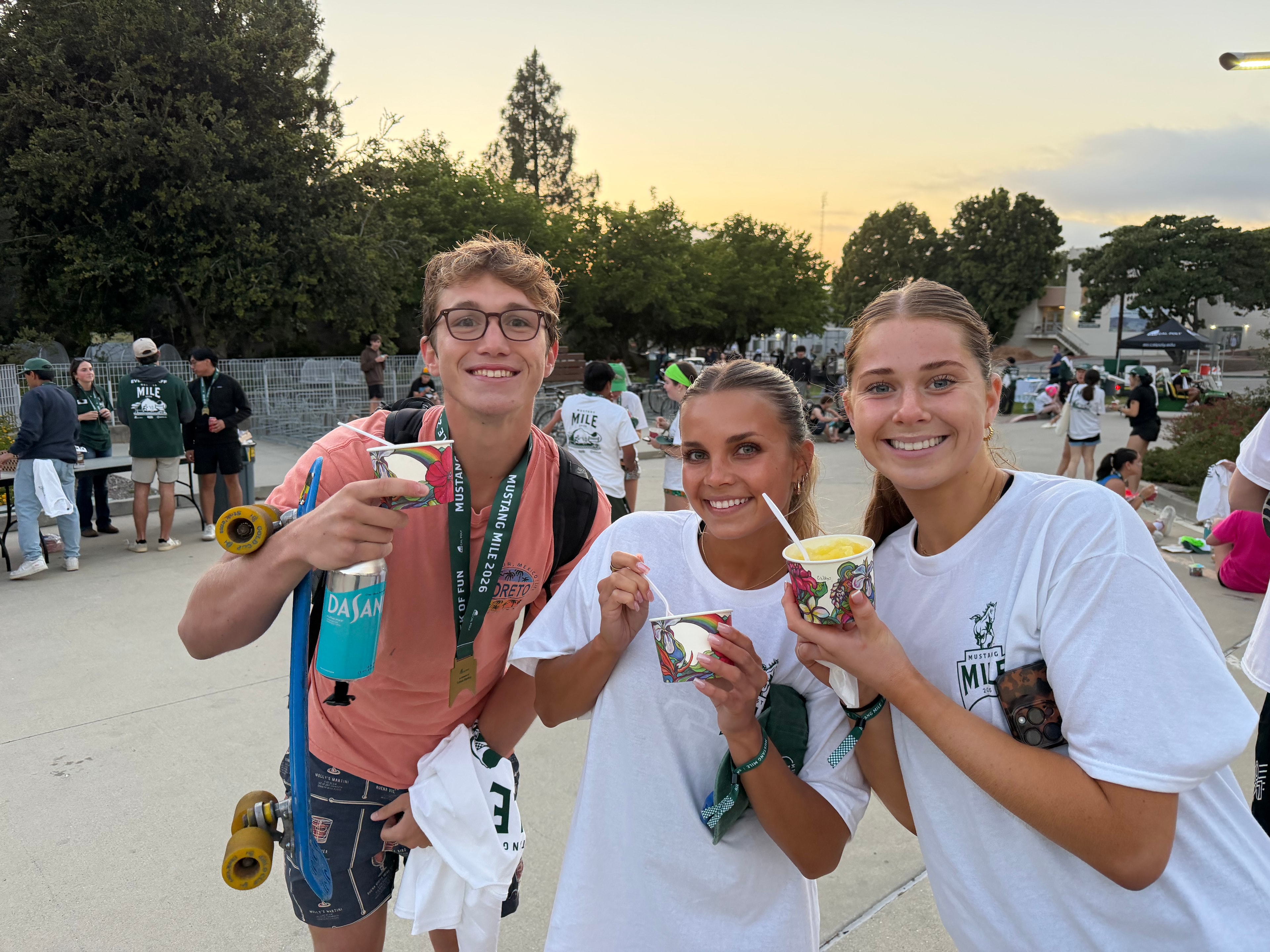 Three friends at the Mustang Mile event enjoying Shaka Shak shave ice at sunset