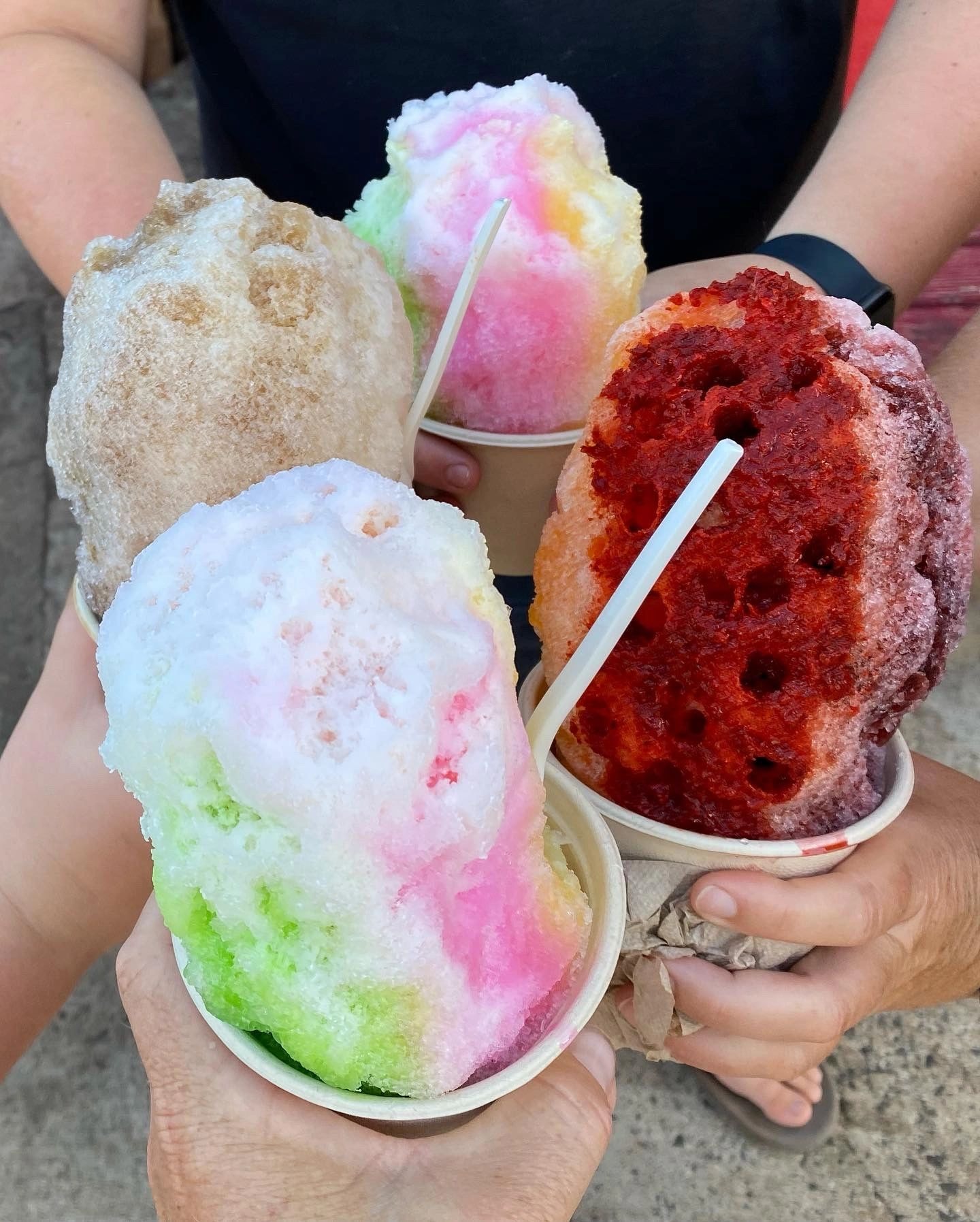 Colorful Hawaiian shave ice cups held by customers